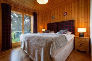 a bedroom with a bed in a room with wooden walls at Jacuzzi & Sauna | Chalet Teremok in La Tzoumaz