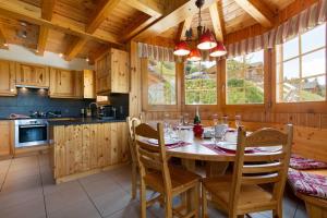 a dining room with a table and chairs in a kitchen at Jacuzzi & Sauna | Chalet Teremok in La Tzoumaz