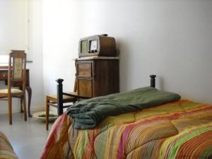 MarrùbiuにあるLa Baliaのベッドルーム(ベッド1台、ドレッサー内のテレビ付)