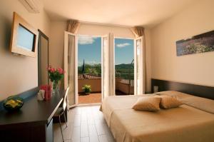 a bedroom with two beds and a large window at Il Puntone Vecchio in Puntone di Scarlino