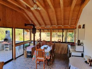a living room with a table and chairs and a kitchen at Casa Haralambie in Greci