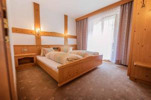 a bedroom with a bed in a room with a window at Hotel Garni Pfandl in Neustift im Stubaital