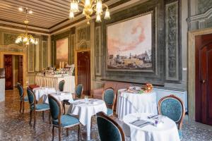 a restaurant with white tables and chairs and a painting at Sogno di Giulietta e Romeo in Venice