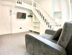 a living room with a couch and a staircase at Empress Select Holiday Flats in Blackpool