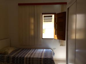 um pequeno quarto com uma cama e uma janela em Casa 1/4 Chapada Diamantina/ibicoara em Ibicoara