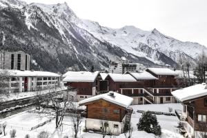 uma cidade coberta de neve com montanhas ao fundo em Appartement La Vallée Blanche avec parking gratuit em Chamonix-Mont-Blanc