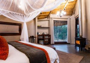 aha Makalali Private Game Lodge في Makalali Game Reserve: غرفة نوم بسرير كبير مع مظلة