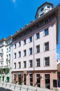 a large white building with a clock tower on top at Three Corners Hotel Art in Budapest