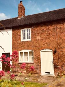 a brick house with a white door and pink flowers at 75 High Street in Melbourne