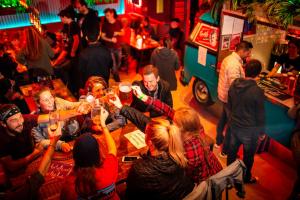 Un gruppo di persone che se ne stanno seduti intorno a un bar a bere di Kick Ass Greyfriars (18+) a Edimburgo