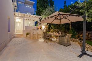 patio con ombrellone e tavolo con sedie di Villa Bella with pool a Novalja (Novaglia)