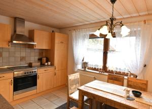 a kitchen with wooden cabinets and a table and a window at Ferienwohnungen Eisler in Abensberg