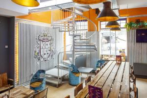 ein Restaurant mit Tisch und Stühlen und einer Wendeltreppe in der Unterkunft Kick Ass Grassmarket (18+) in Edinburgh