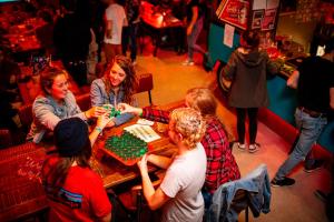Eine Gruppe von Menschen sitzt um einen Tisch und spielt ein Spiel in der Unterkunft Kick Ass Grassmarket (18+) in Edinburgh