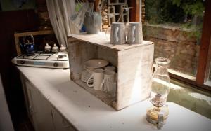 a kitchen counter with a wooden box with cups and a bottle at Bethany Farm in Twee Riviere