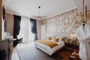 a bedroom with a large white bed and a wall at La Villa Guy & Spa - Teritoria in Béziers