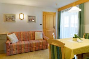 - un salon avec un canapé et une table dans l'établissement Apartments Residence Montana, à Rasun di Sopra