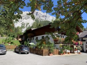 a building with a snow covered mountain in the background at Haus Latschenheim in Ramsau am Dachstein