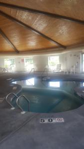 uma grande piscina num edifício com mesas e cadeiras em Windsor Place Inn em Prairie du Chien