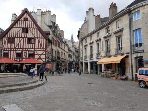eine Stadtstraße mit Gebäuden und Menschen, die eine Straße hinuntergehen in der Unterkunft Le Jim : Rue Musette in Dijon
