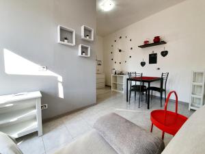 a living room with a red chair and a table at LA MAISON DELUXE LODI in Lodi