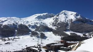 una montagna innevata con un rifugio e una pista sciistica di Il viandante a Sulmona