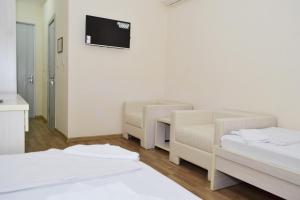 a room with two beds and a desk and a tv at Pakhtakor Athletics hotel in Tashkent
