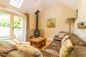 a living room with a couch and a fireplace at Robin Hood Farm B&B in Baslow