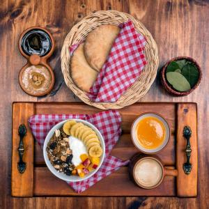 a table with a plate of food and a basket of bread at KACLLA, The Healing Dog Hostel in Lima