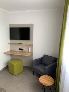 a living room with a couch and a tv at Weingut Bugner Meizelhof in Klein-Winternheim