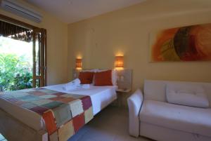 1 dormitorio con 1 cama y 1 sofá en Pousada Vento Sul, en Ilhabela