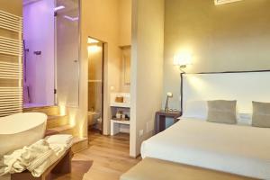 a hotel room with a bed and a bathroom at Il Torrino - Daria Monticchiello in Pienza