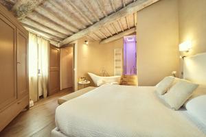 a bedroom with a bed and a bathroom with a tub at Il Torrino - Daria Monticchiello in Pienza