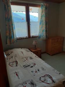 Schlafzimmer mit einem Bett und einem Fenster in der Unterkunft Gîte Les Grands Champs in Bellentre