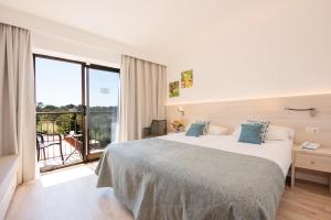 Cette chambre dispose d'un grand lit et d'un balcon. dans l'établissement Hotel Playa Mondrago, à Portopetro