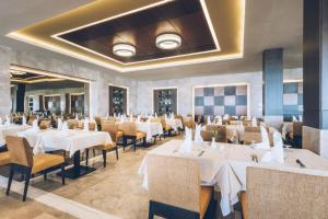 a dining room with white tables and chairs at Iberostar Selection Kuriat Palace in Monastir