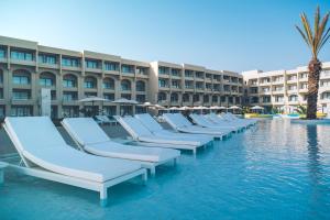 a row of chaise lounges in a pool at a resort at Iberostar Selection Kuriat Palace in Monastir
