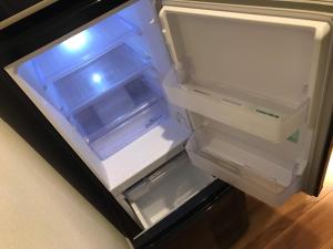 an empty refrigerator with its door open in a kitchen at Local Hakata apartment No11 in Fukuoka
