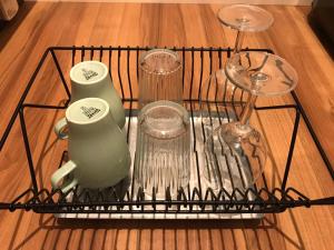 a wire rack with dishes and glasses on a table at Local Hakata apartment No11 in Fukuoka