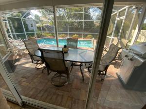 a patio with a table and chairs and a pool at Modern Pool Home in Spring Hill