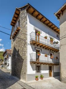 un edificio blanco con balcones y macetas en Casa Marosa, en Ansó