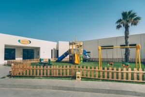 a playground in front of a building with a fence at Iberostar Selection Kuriat Palace in Monastir
