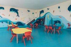 a classroom with tables and chairs and a dolphin mural at Iberostar Selection Kuriat Palace in Monastir