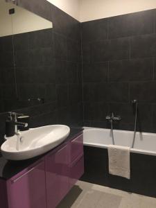 a bathroom with a white sink and a tub at Lulù in Impruneta