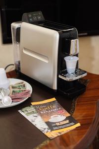 una tostadora sentada en una mesa junto a una revista en Boutique Hotel L'Imperatrice, en Foiano della Chiana