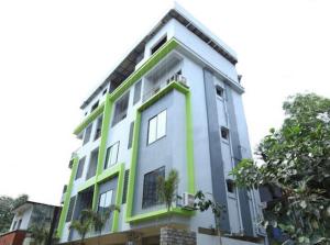 a white and green building with trees in front of it at JK Rooms 126 Parashar Legacy - Opp Railway Station in Nagpur