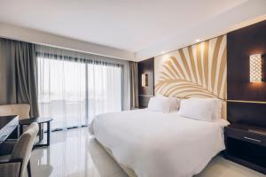 a hotel room with a large bed and a desk at Iberostar Selection Kuriat Palace in Monastir