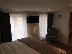 Schlafzimmer mit einem Bett, einem Stuhl und Fenstern in der Unterkunft HOTEL HOVI DE LA MAIRIE in Aubervilliers