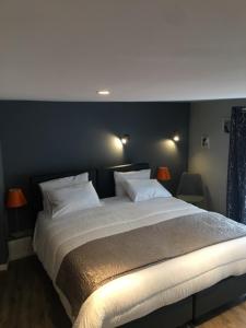 Un dormitorio con una cama grande con dos almohadas. en HOTEL HOVI DE LA MAIRIE, en Aubervilliers