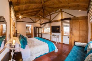 1 dormitorio con 1 cama y TV en una habitación en Hosteria Caballo Campana, en Cuenca